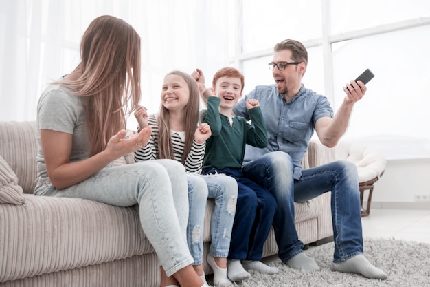 Glückliche Familie sitzt vor dem Fernseher in ihrem Homephoto mit Kopierraum