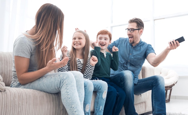 Glückliche Familie sitzt vor dem Fernseher in ihrem Homephoto mit Kopierraum