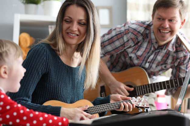 Glückliche Familie spielt Musikinstrumente auf Hintergrund