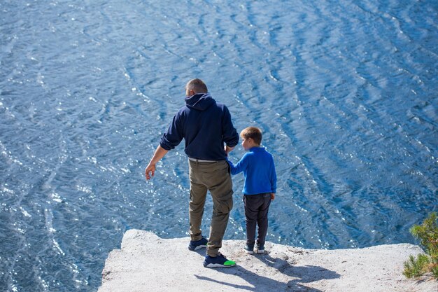 Glückliche Familie Vater spielt mit Sohn im Freien Positive menschliche Emotionen Gefühle Freude am See im Korostyshiv-Steinbruch Zhytomyr-Distrikt im Norden der Ukraine