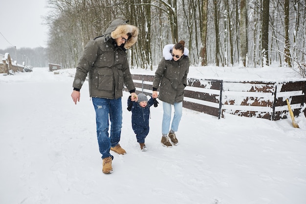 Glückliche Familie viel Spaß draußen in der Nähe des Hauses im Winter. Familienurlaub und Happy Time Konzept