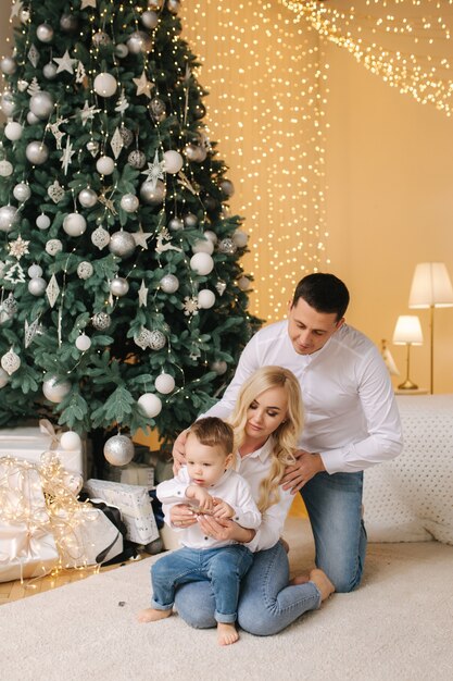 Glückliche Familie von Mama, Papa und kleinem Sohn zu Hause in der Weihnachtszeit. Glückliche Momente.