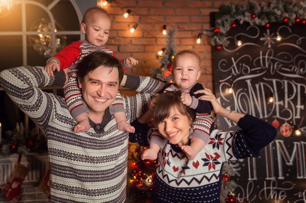 Glückliche Familie von vier Mama, Papa und Babys Zwillinge, die zusammen Weihnachten lächeln