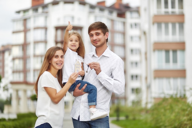 Glückliche Familie vor neuem Wohngebäude