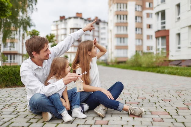 Glückliche Familie vor neuem Wohngebäude