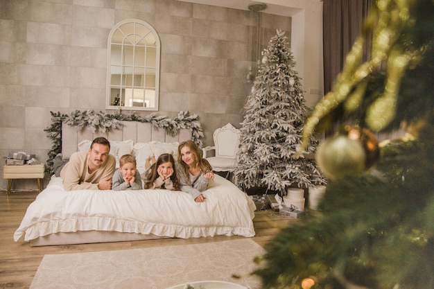 Glückliche Familie zu Hause auf dem Bett Konzept des neuen Jahres