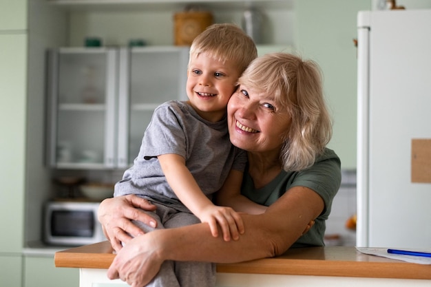 Glückliche Familiengroßmutter umarmt ihren Enkel zu Hause