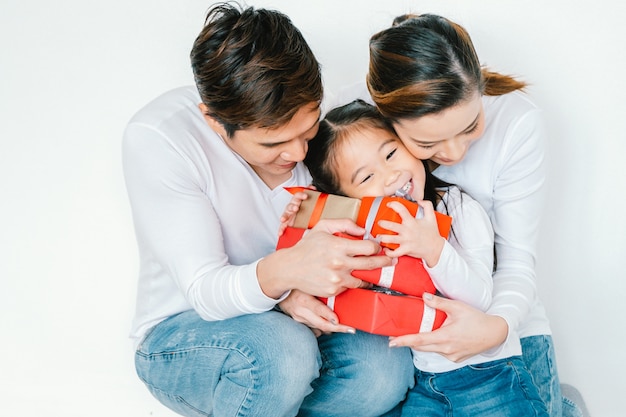 Glückliche Familienmutter, Vater, Kindertochter zu Hause mit giftbox Weihnachten, guten Rutsch ins Neue Jahr-Parteikonzept