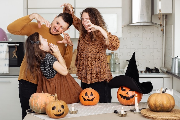 Glückliche Familienmutter, Vater und Tochter, die Halloween zu Hause feiern. Fröhliches Halloween.