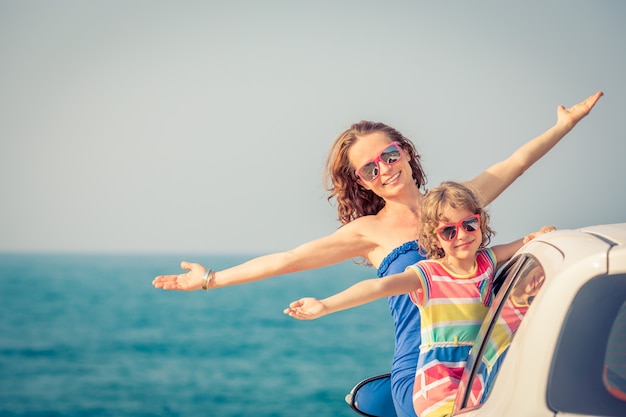 Glückliche Familienreisen mit dem Auto Leute, die Spaß am Strand haben Sommerferienkonzept