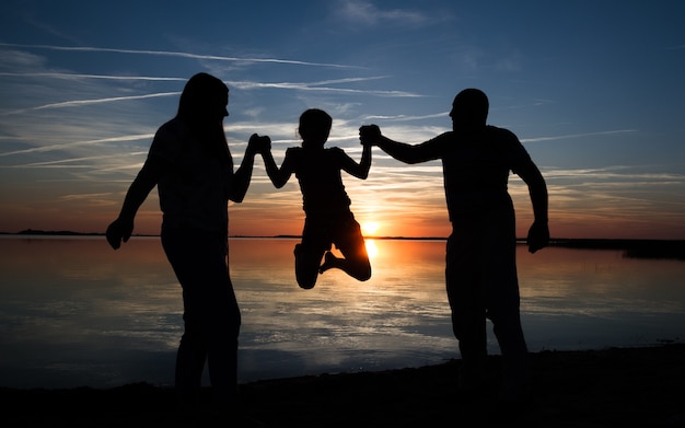 Glückliche Familiensilhouette am Strand