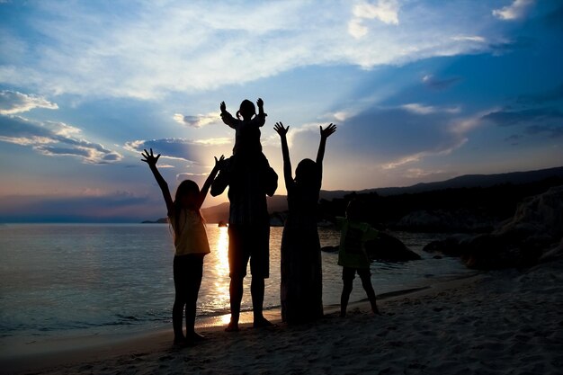 Foto glückliche familiensilhouette im hintergrund des griechischen meeres