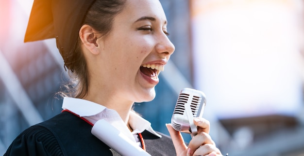 Glückliche Frau an ihrem Abschlusstag Universität