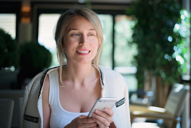 Glückliche frau, die am telefon im restaurant spricht