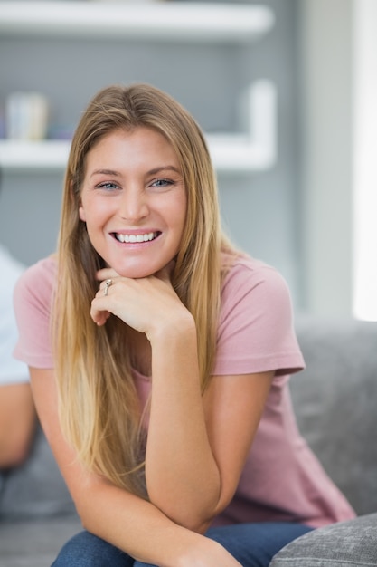 Glückliche Frau, die auf Couch sitzt