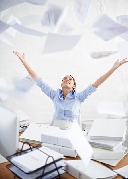 Foto glückliche frau, die dokumente im büro wirft