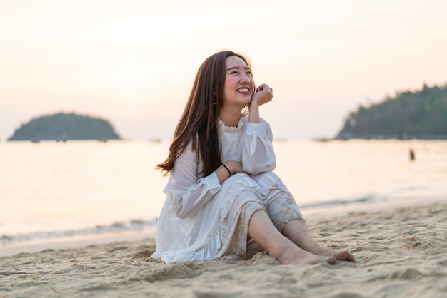 Glückliche Frau, die durch das Meer lächelt