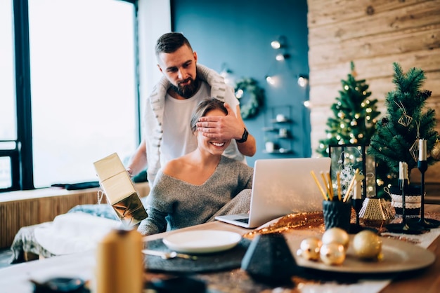 Glückliche Frau, die ein Weihnachtsgeschenk vom Partner bekommt