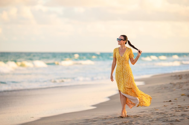 Glückliche Frau, die einen schönen Sonnenuntergang am Strand genießt