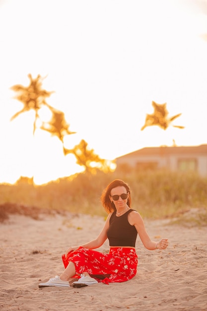 Glückliche Frau, die einen schönen Sonnenuntergang am Strand genießt