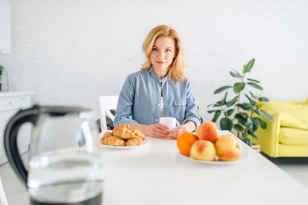 Glückliche Frau, die Frühstück auf der Küche kocht