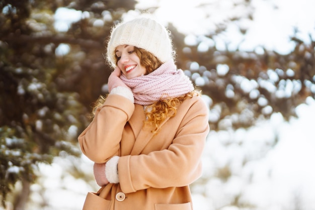 Glückliche Frau, die in den verschneiten Wintertag im Freien geht Wintermodeferien ruhen Reisekonzept