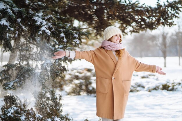 Glückliche Frau, die in den verschneiten Wintertag im Freien geht Wintermodeferien ruhen Reisekonzept