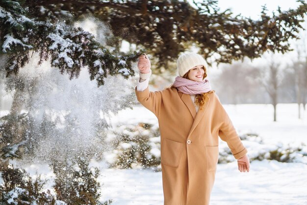 Glückliche Frau, die in den verschneiten Wintertag im Freien geht Wintermodeferien ruhen Reisekonzept