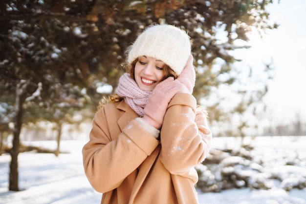 Glückliche Frau, die in den verschneiten Wintertag im Freien geht Wintermodeferien ruhen Reisekonzept