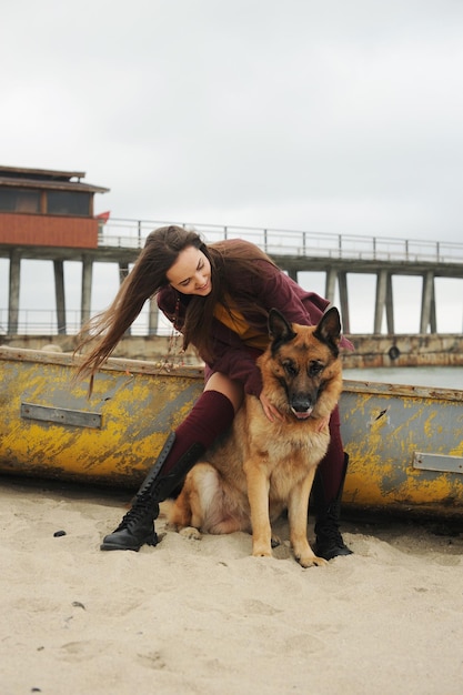 Glückliche Frau, die mit ihrem deutschen Schäferhund spielt