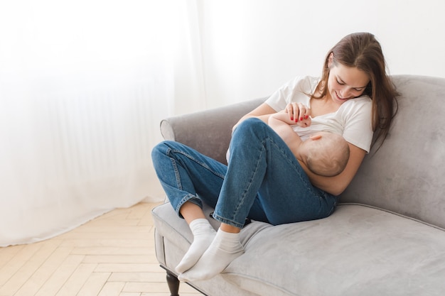 Glückliche Frau, die mit Kind auf Sofa streichelt