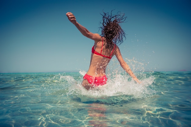 Glückliche Frau, die Spaß im Meer hat