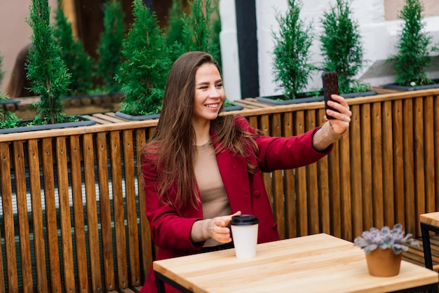 Glückliche Frau im Café im Freien trinken und lächeln