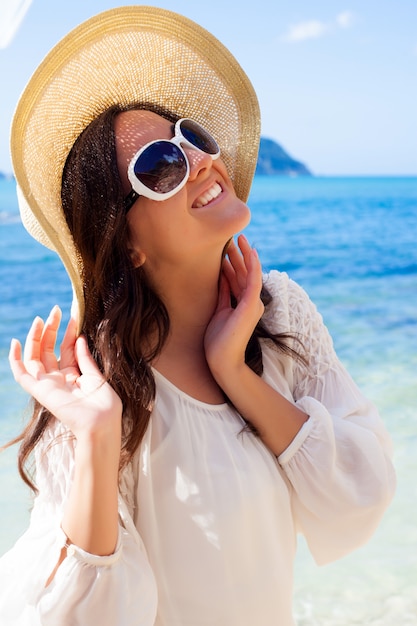 Glückliche Frau im Hut am Strand