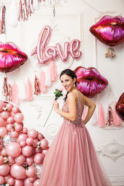 Glückliche Frau im Tüllkleid mit rosa Ballons. Luxus