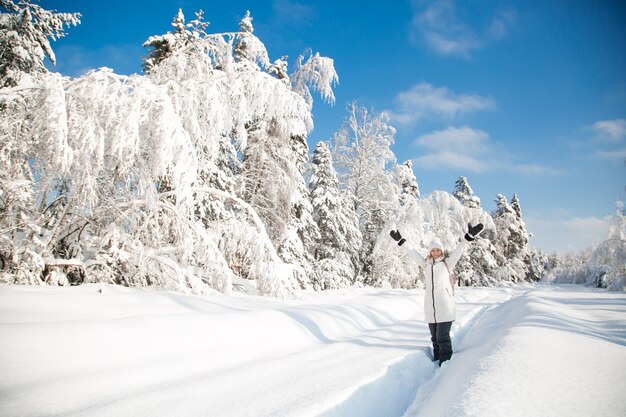 Glückliche Frau im verschneiten Winterwald