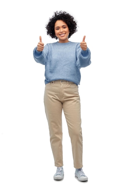glückliche Frau in blauem Pullover zeigt Daumen hoch