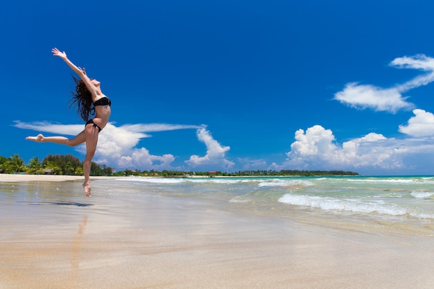 Glückliche Frau in einem Sprung am Strand