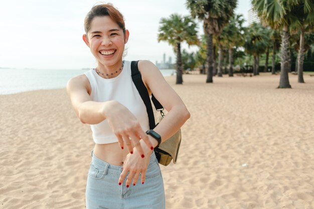 Glückliche Frau lacht und geht am Strand spazieren