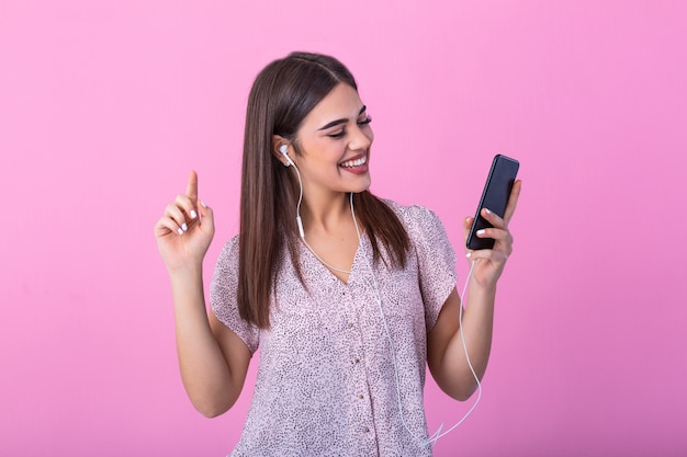 Glückliche Frau lächelnd und hält Handy lokalisiert über rosa