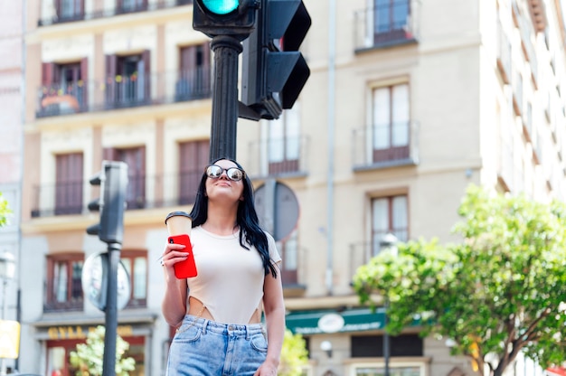 glückliche Frau mit dem Handy auf der Straße.