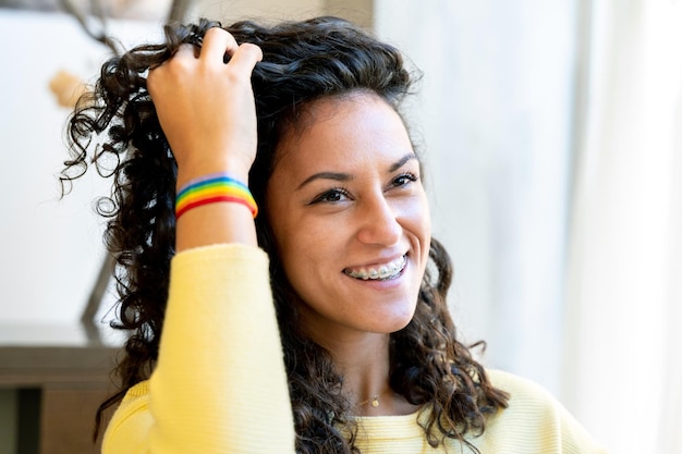 Glückliche Frau mit einem Regenbogen-LGBT-Armband in einem Salon