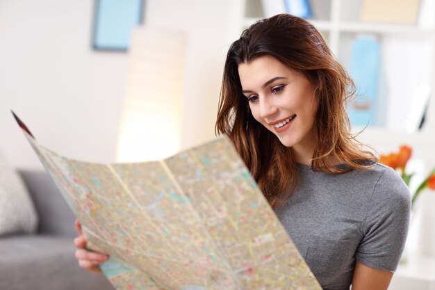 glückliche Frau mit Karte zu Hause, die Ferien plant planning