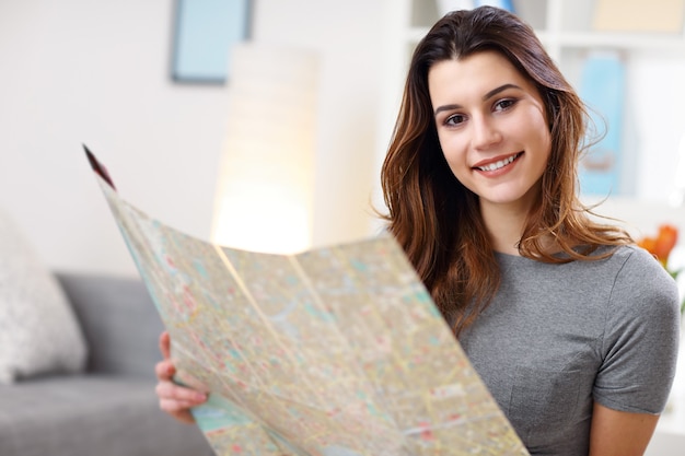 glückliche Frau mit Karte zu Hause, die Ferien plant planning