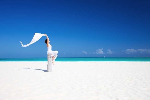 glückliche Frau mit weißem Sarong am Strand