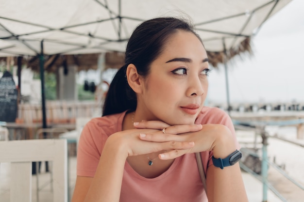 Glückliche Frau sitzt im Restaurant am Strand.