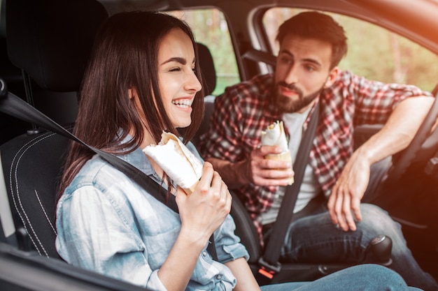 glückliche Frau sitzt mit ihrem Partner im Auto und lacht