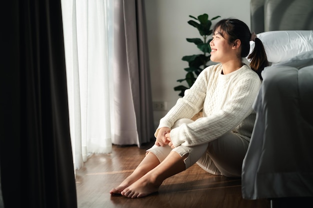 Foto glückliche frau sitzt morgens im schlafzimmer