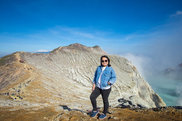 glückliche Frau steht an der Spitze Kawah ijen