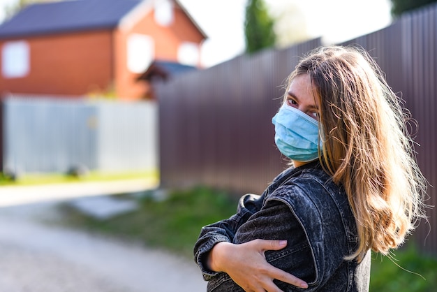 glückliche Frau trägt eine medizinische Maske, weil Luftverschmutzung oder Virus eine Epidemie in der Stadt ist.